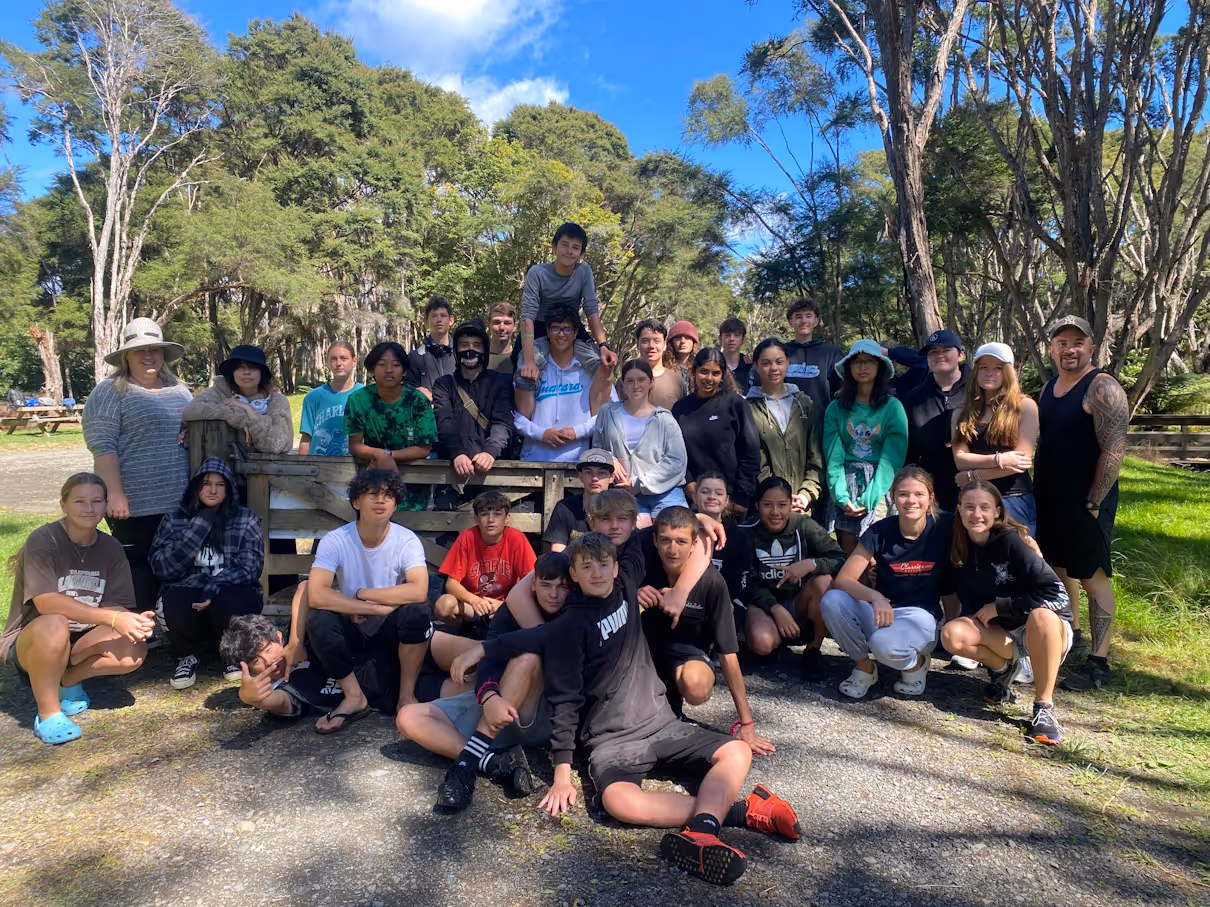 Students and staff gathered together among the trees on an EOTC trip